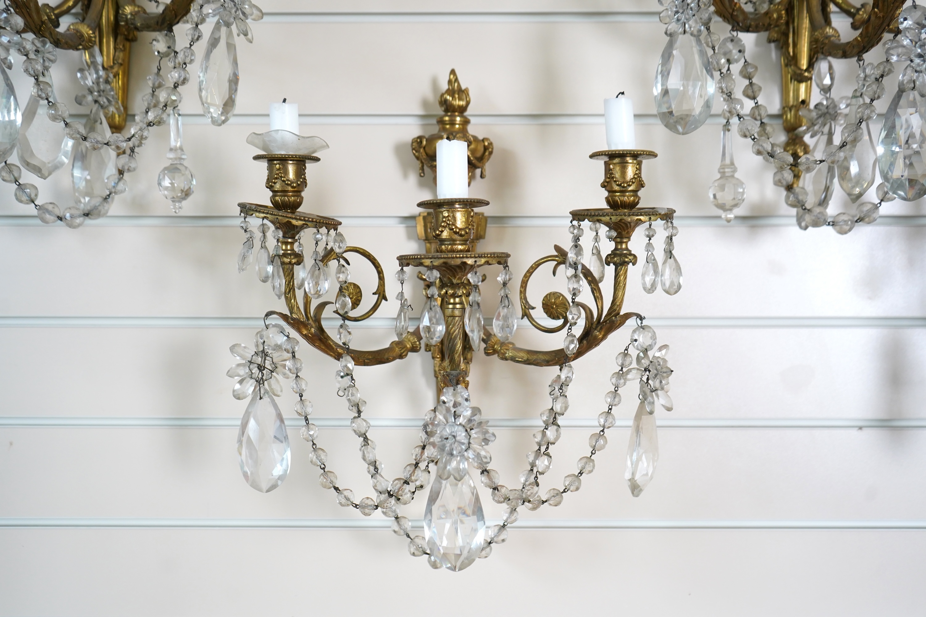 A set of four Louis XVI style ormolu and crystal wall sconces